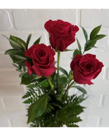 Trois roses dans une composition florale de vase