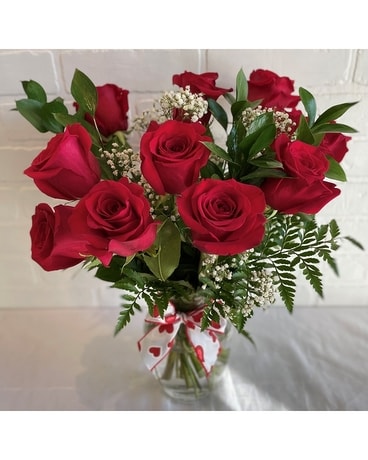 Douze roses rouges disposées en fleurs de vase