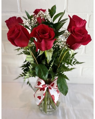 Six roses rouges dans un arrangement de fleur de vase