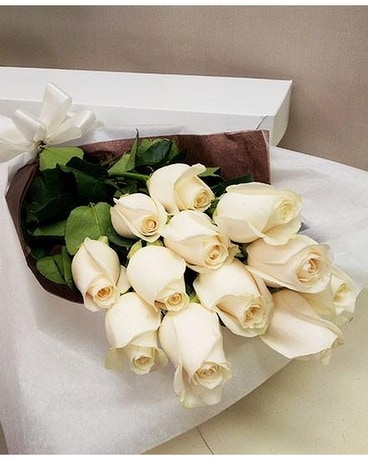 Douze roses blanches disposées dans une boîte fleurie